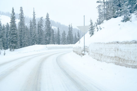 Snowy mountain highway with curveの写真素材