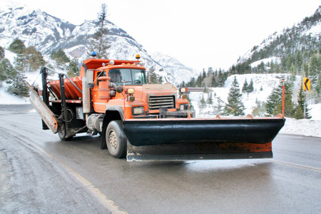 Snowplow on wet mountain highway