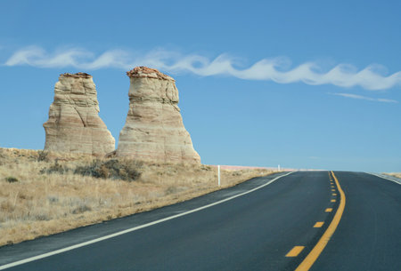 desert highway with rock outcropping in arizonaの写真素材