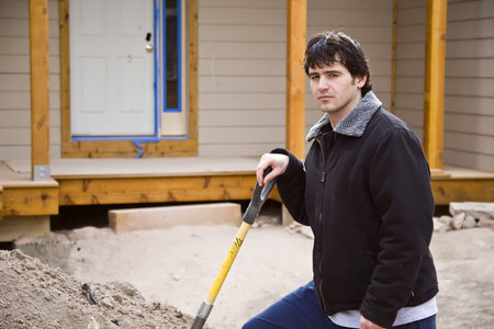 A construction worker in front of new house