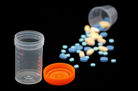 Urine sample bottle and pills.