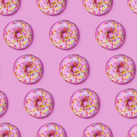 Bright flat seamless pattern with donuts. Pink glazed donuts with colorful sugar sprinkles on pink...
