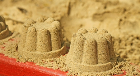 A sand cake on the sand on a white background 