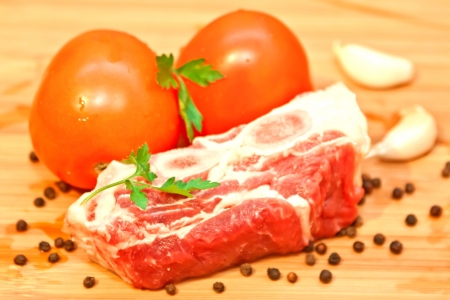 Raw beef with spices and vegetables on the cutting boardの写真素材