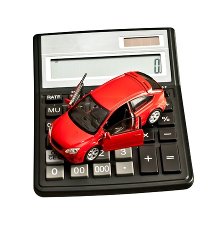 Toy car and calculator over white. Rent, buy, repair or insurance car conceptの写真素材