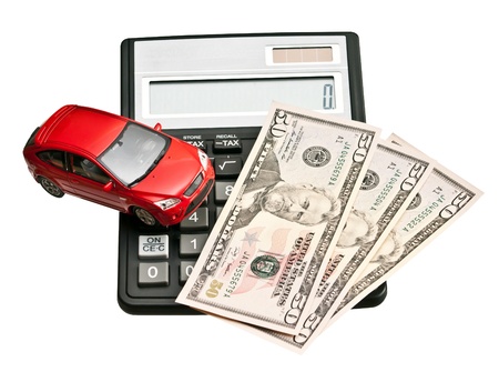 Toy car and calculator  Concept for buying, renting, insurance, fuel, service and repair costsの写真素材