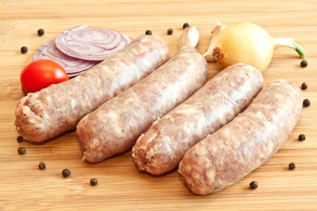 Uncooked sausages with vegetables on the chopping board
の写真素材
