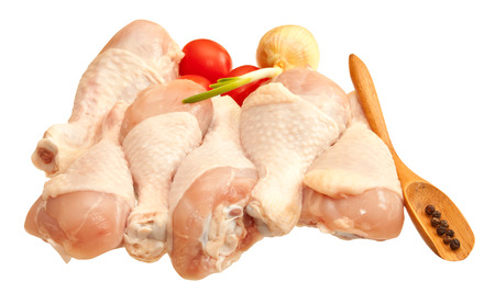 Raw chicken legs with vegetables, isolated on white backgroundの写真素材