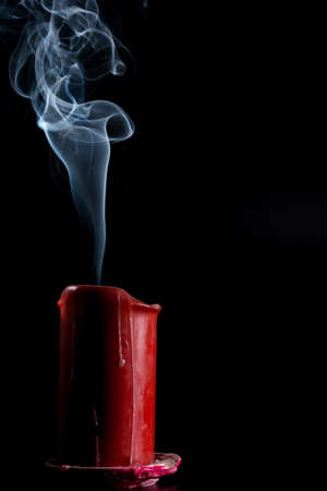 extinguished the candle of red color on a black backgroundの写真素材