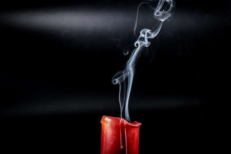 gray smoke flying upside from the extinct red candlesの写真素材
