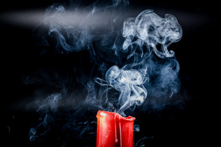 gray smoke flying upside from the extinct red candlesの写真素材