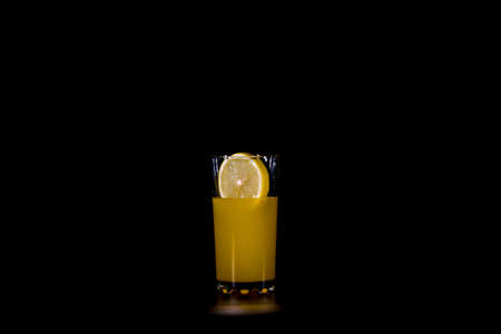 a slice of citrus fruit dropped into a glass of fruit cocktailの写真素材