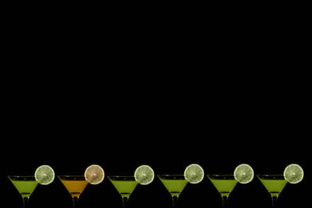 black background with glasses of orange juice and kiwi fruit at the bottomの写真素材
