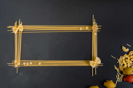 spaghetti and other pasta as a frame on a dark backgroundの写真素材