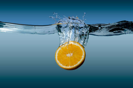 tropical citrus orange fruit in water on a blue backgroundの写真素材