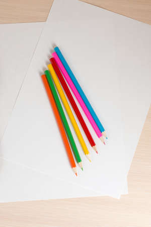 colored pencils to draw lying on a blank sheet of paperの写真素材