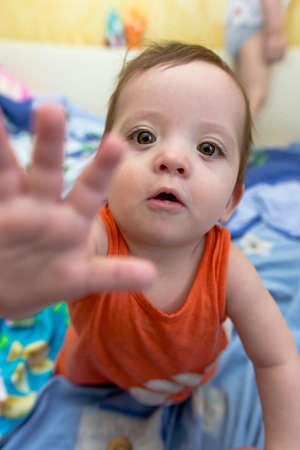 baby crawling on the bed and stretches forwardの写真素材