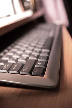 computer keyboard on the table in the light of the monitorの写真素材