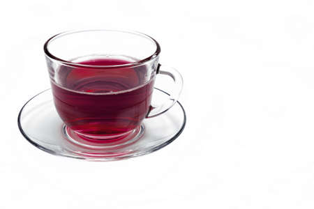 transparent glass cup with Hibiscus tea on a saucer isolated on a white backgroundの写真素材