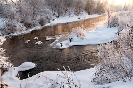 sunrise over a frozen river in the winterの写真素材