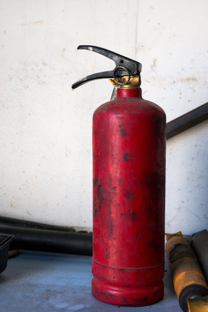 The old fire extinguisher stands on the shelf
