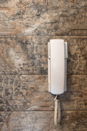 White phone attached to a stone wallの写真素材