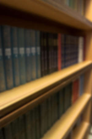 Books stand in a bookcase with a blur effectの写真素材