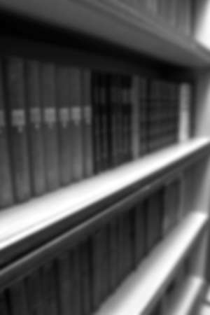 Books stand in a bookcase with a blur effectの写真素材