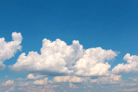 White fluffy big clouds against blue skyの写真素材