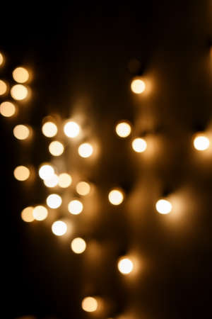 blurred light bulbs on a dark wallの写真素材
