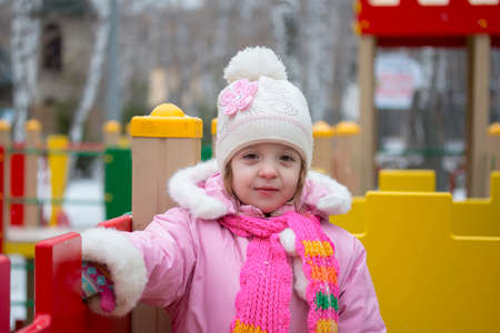 child on a children's playground in winterの写真素材
