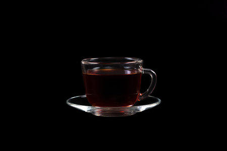 transparent cup of tea isolated on black