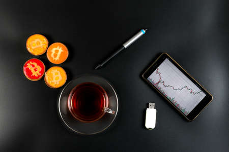 cookies bitcoin and tea on the trader's desktopの写真素材