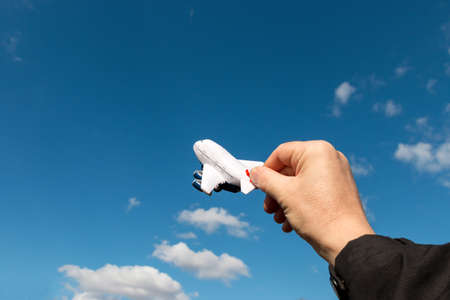 model of passenger airplane in hand on blue sky backgroundの写真素材