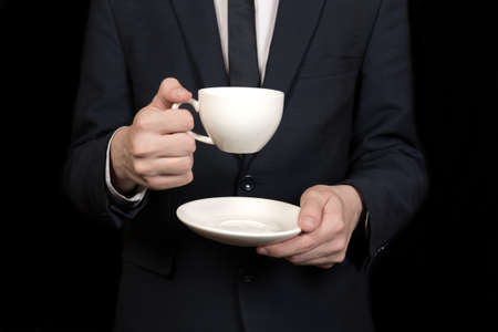 businessman holding a white cup of tea in handsの写真素材