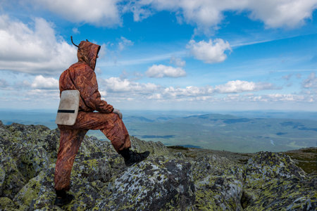 man stands on the top of a mountain and looks at the mountain landscape