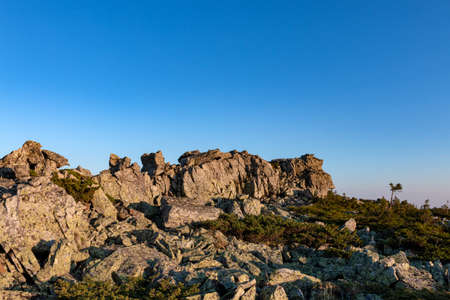 the rock rises against the blue sky in the rays of dawnの写真素材