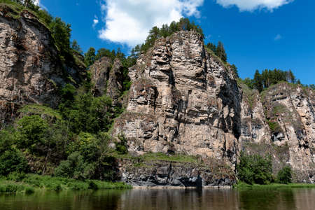 the rock rises against the blue sky in the rays of dawnの写真素材