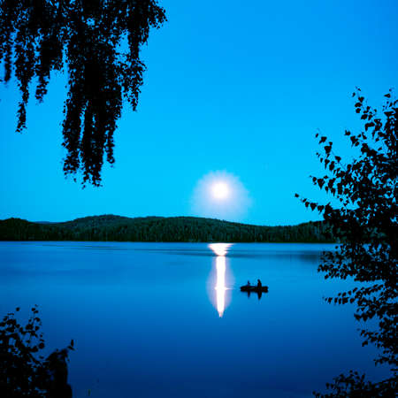 fantastic night landscape with moon over summer lakeの写真素材