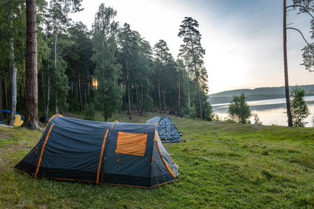 rest in a tourist tent on the shore of a picturesque lake on a summer day