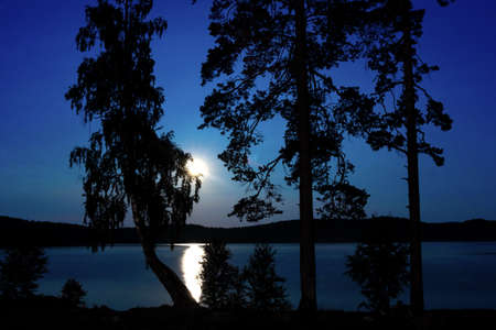 fantastic night landscape with moon over summer lakeの写真素材