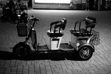 an electric car for transporting tourists stands at night on the roadの写真素材