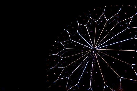 illumination on a ferris wheel in an amusement park at nightの写真素材