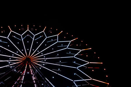 illumination on a ferris wheel in an amusement park at nightの写真素材