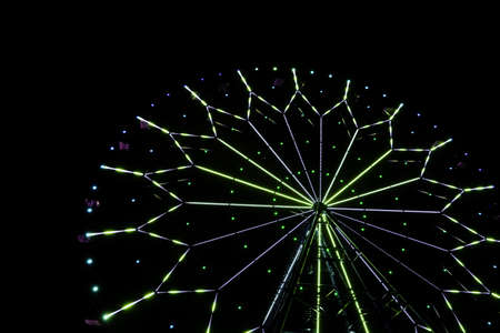 illumination on a ferris wheel in an amusement park at nightの写真素材