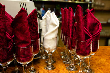 red napkins in glasses prepared for table setting in a restaurantの写真素材