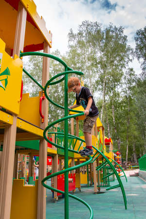 boy playing on the playground on a nice summer dayの写真素材