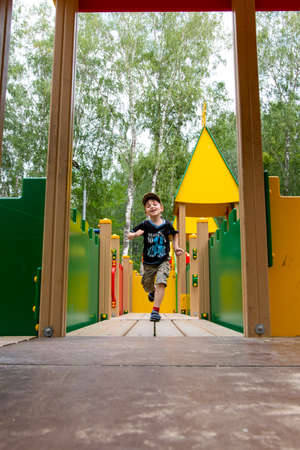 boy runs on the playground on a summer dayの写真素材