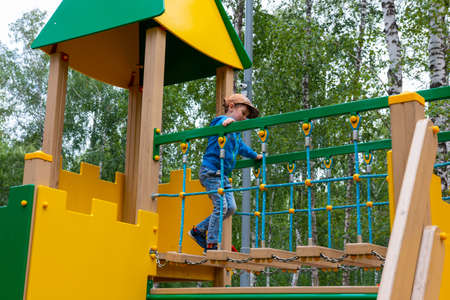 boy runs on the playground on a summer dayの写真素材