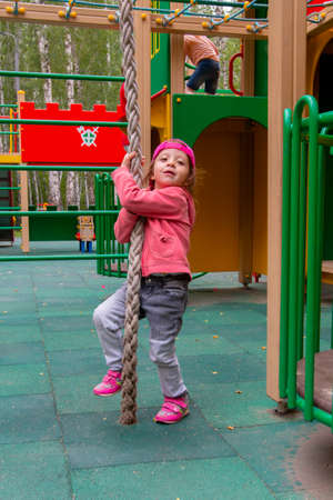 girl playing in the playground in summerの写真素材